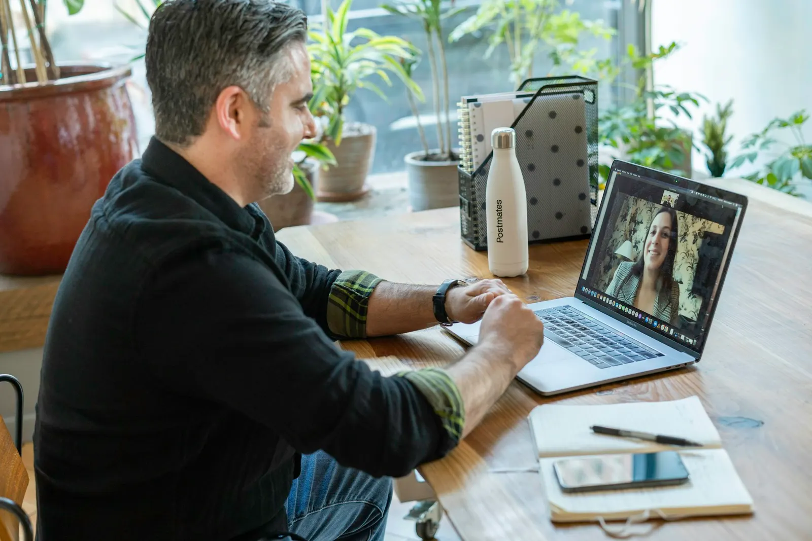 Man in a black sweater on a laptop video call with a client