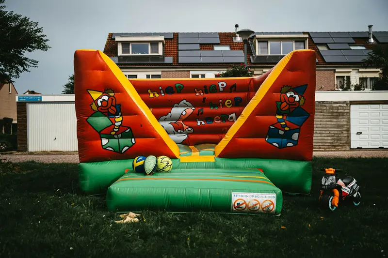 Colorful inflatable bounce house set up on a backyard lawn for a kids party