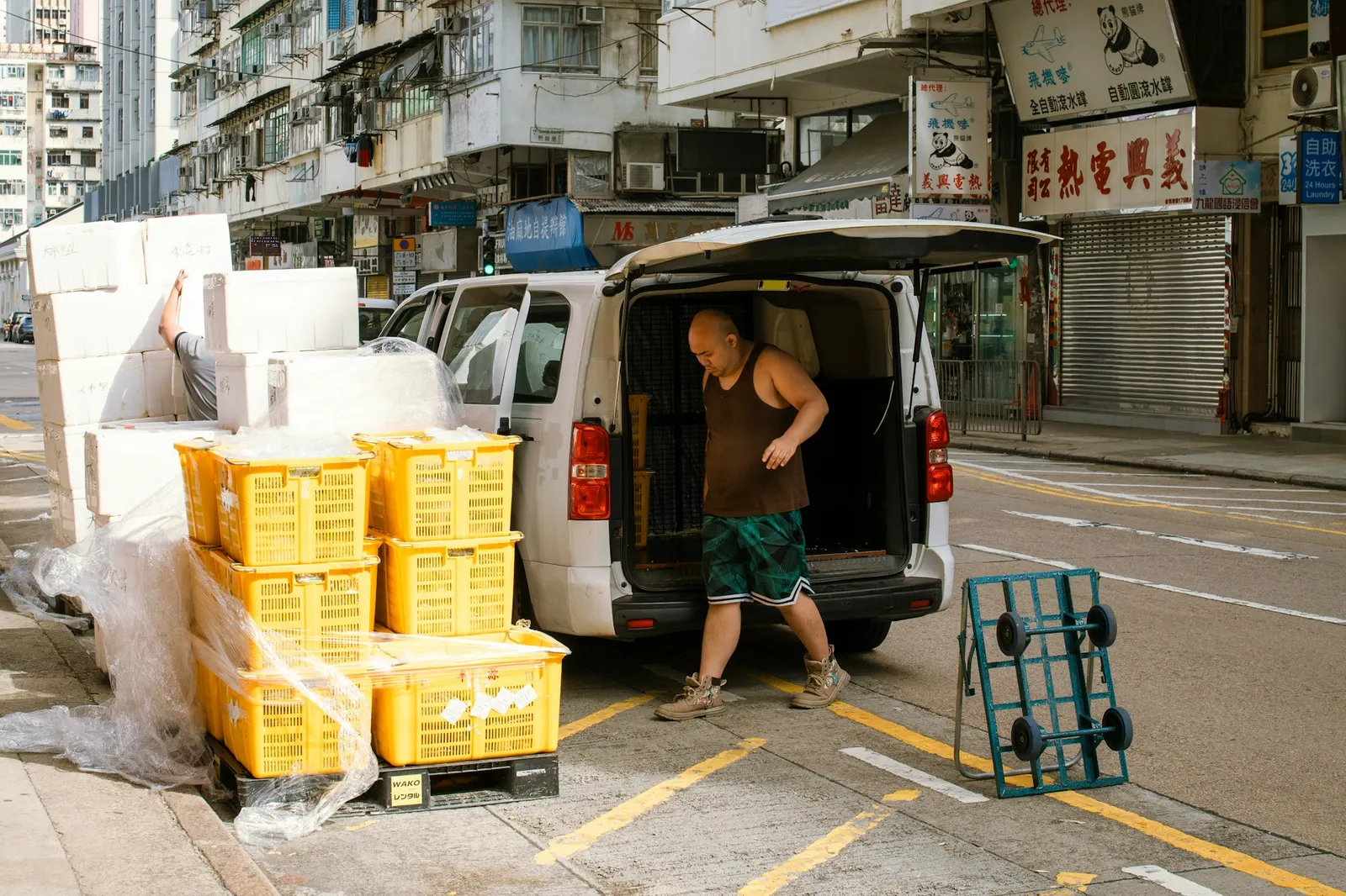 Delivery driver unloading yellow crates from the back of a van
