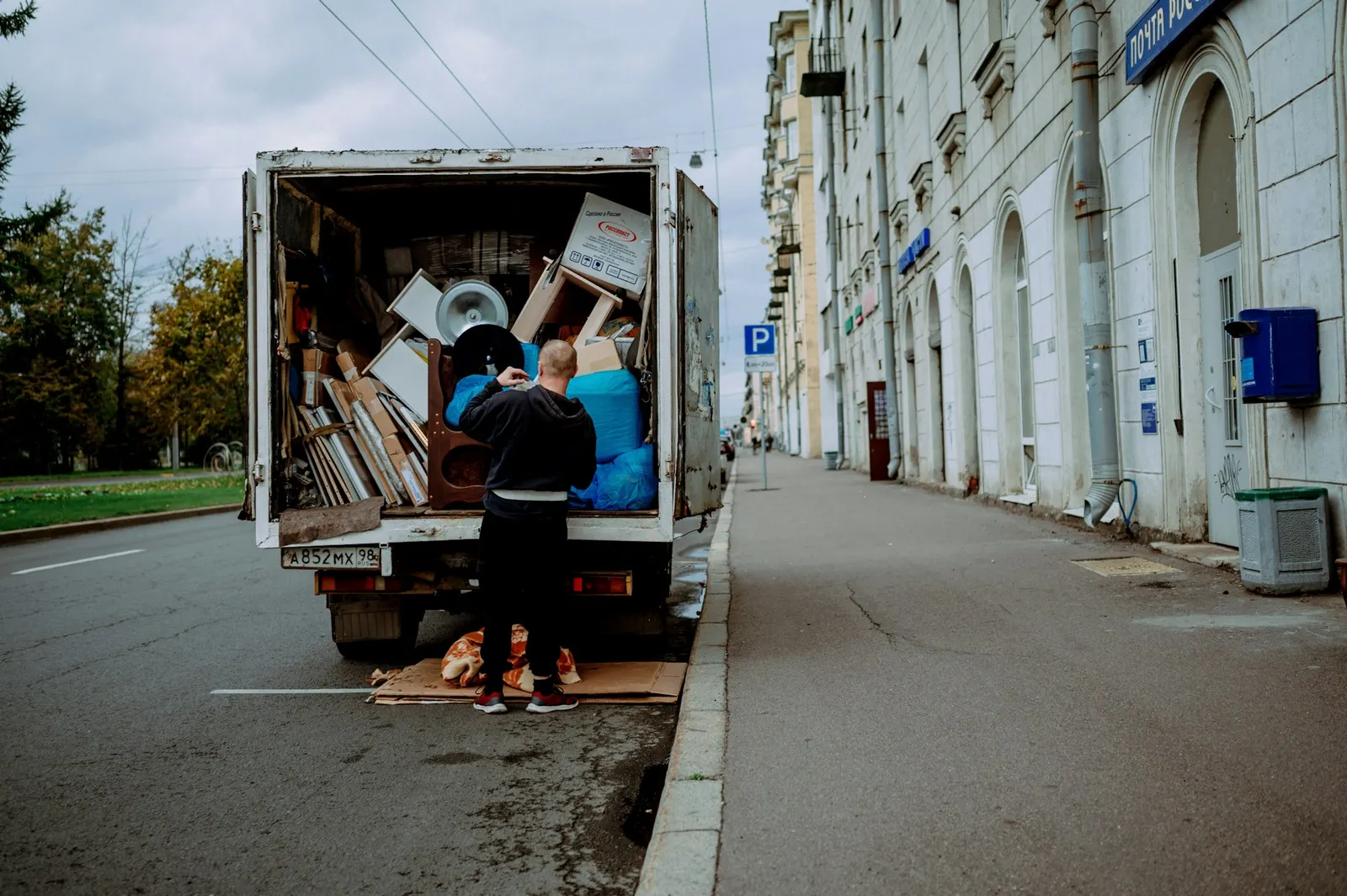 Mover unloading furniture from the open back of a moving truck
