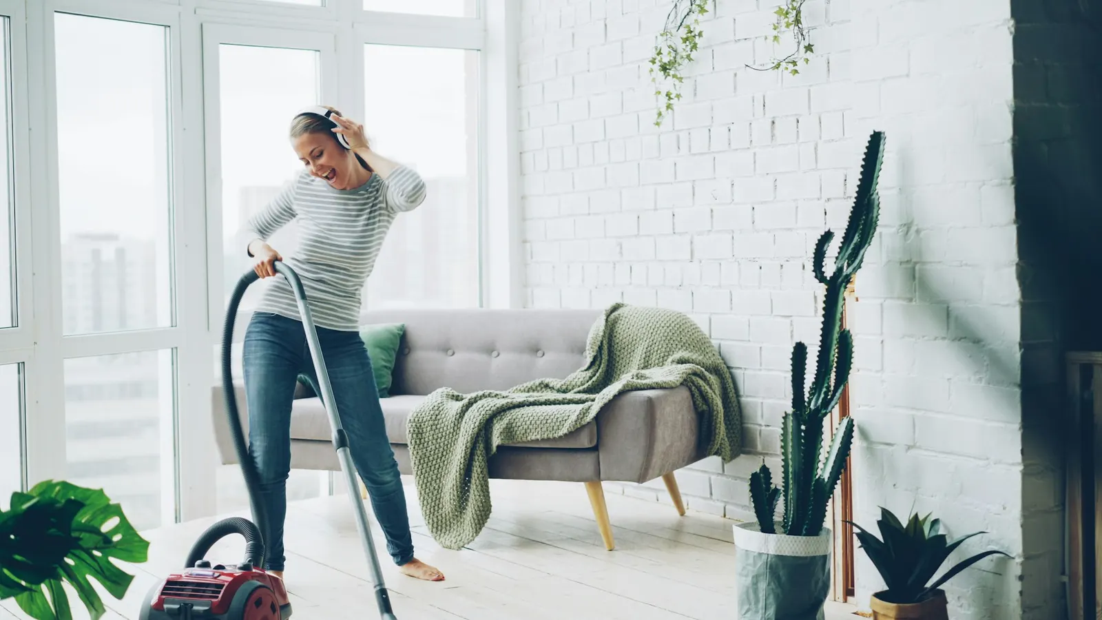 Woman vacuuming the floor of a bright, modern living room