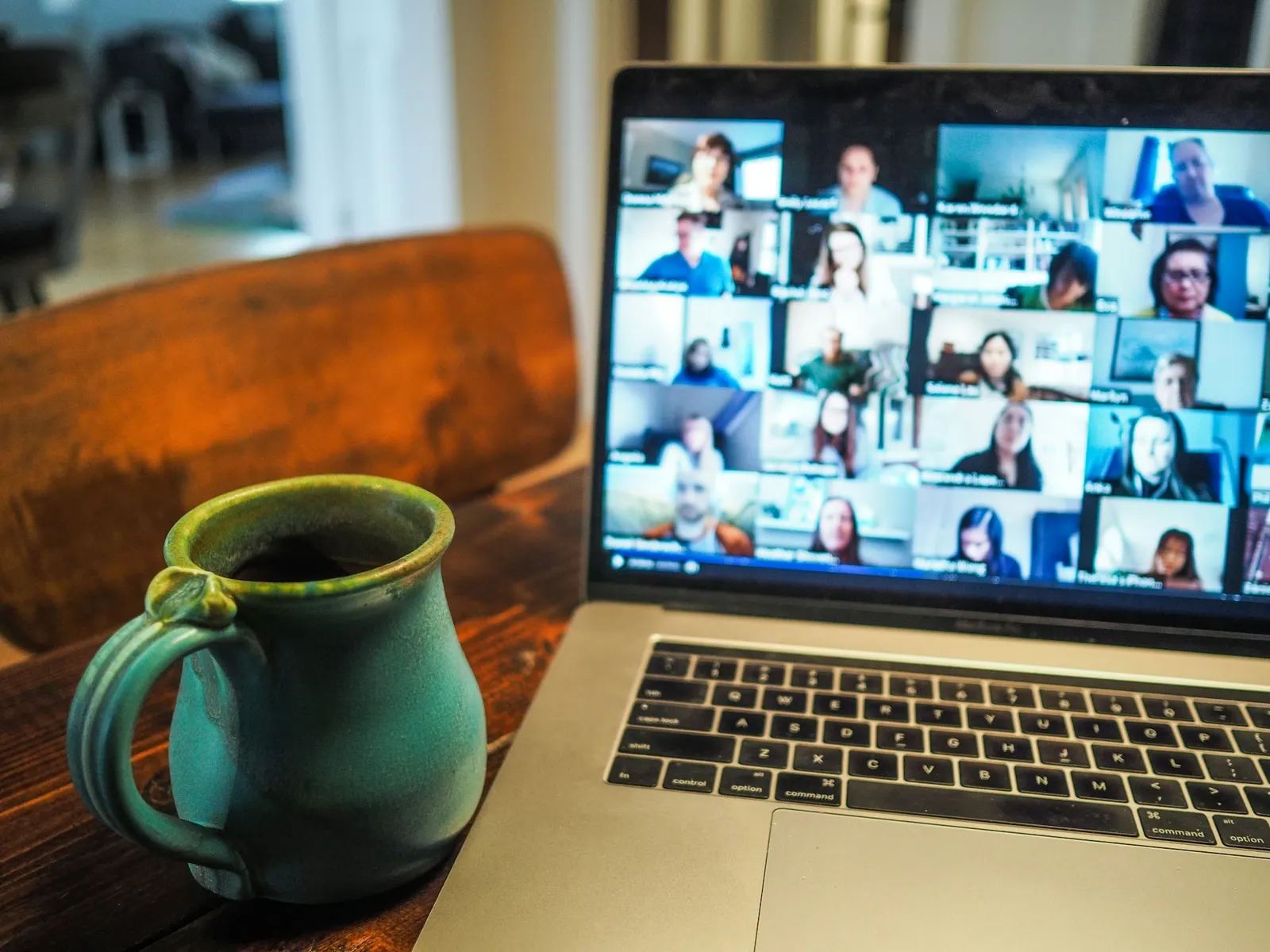 Laptop displaying a video call with a grid of client faces