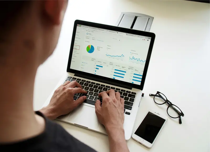 Marketer reviewing an analytics dashboard with charts on a laptop