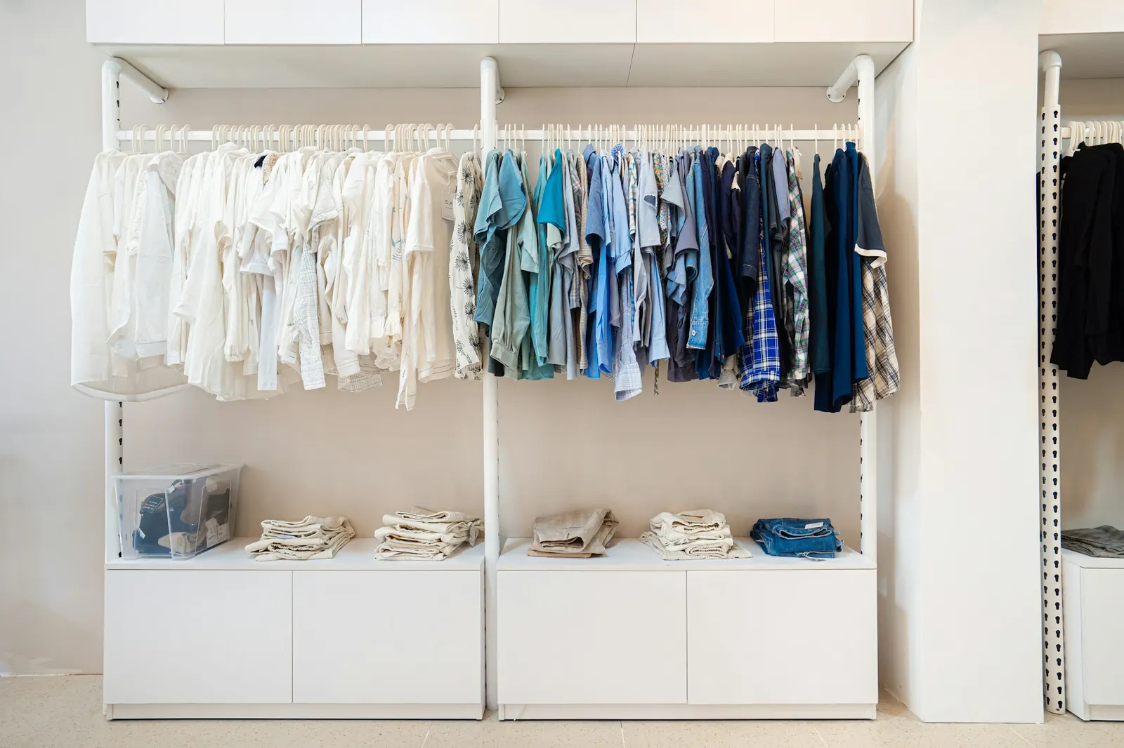 White closet with shirts hung in a gradient from white to navy