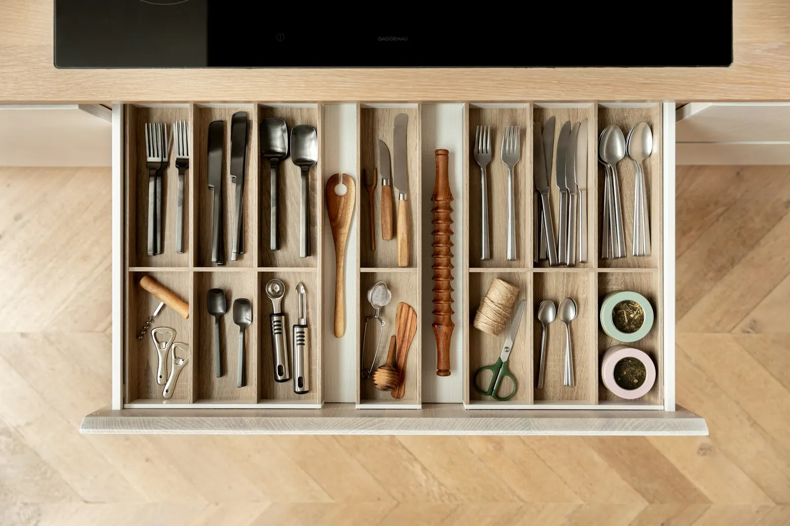 Kitchen drawer with wooden dividers keeping cutlery and utensils tidy