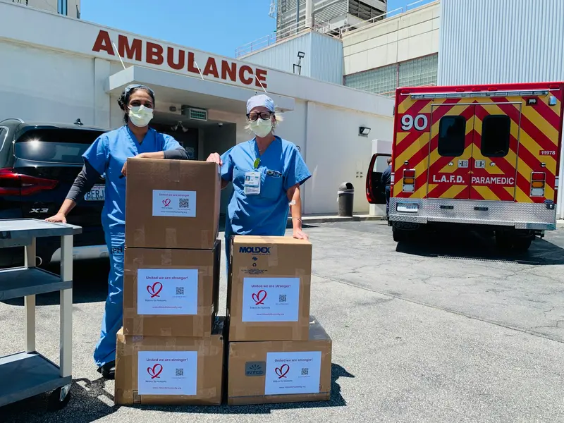 Hospital staff receiving a delivery of boxed medical supplies outside the ambulance bay