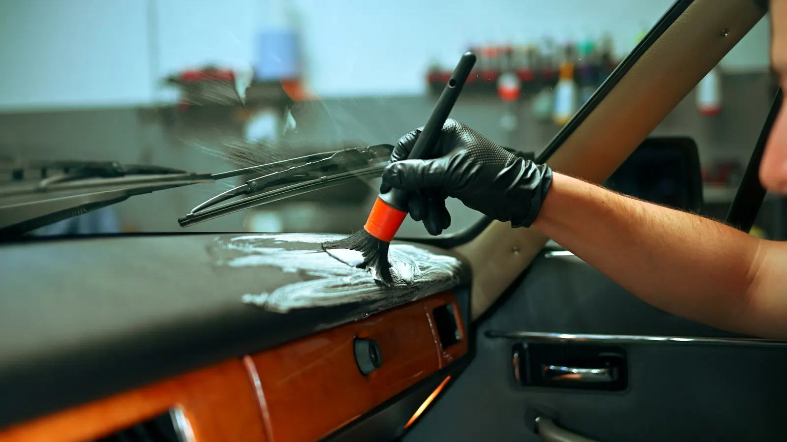 Detailer cleaning the dashboard and interior of a classic car