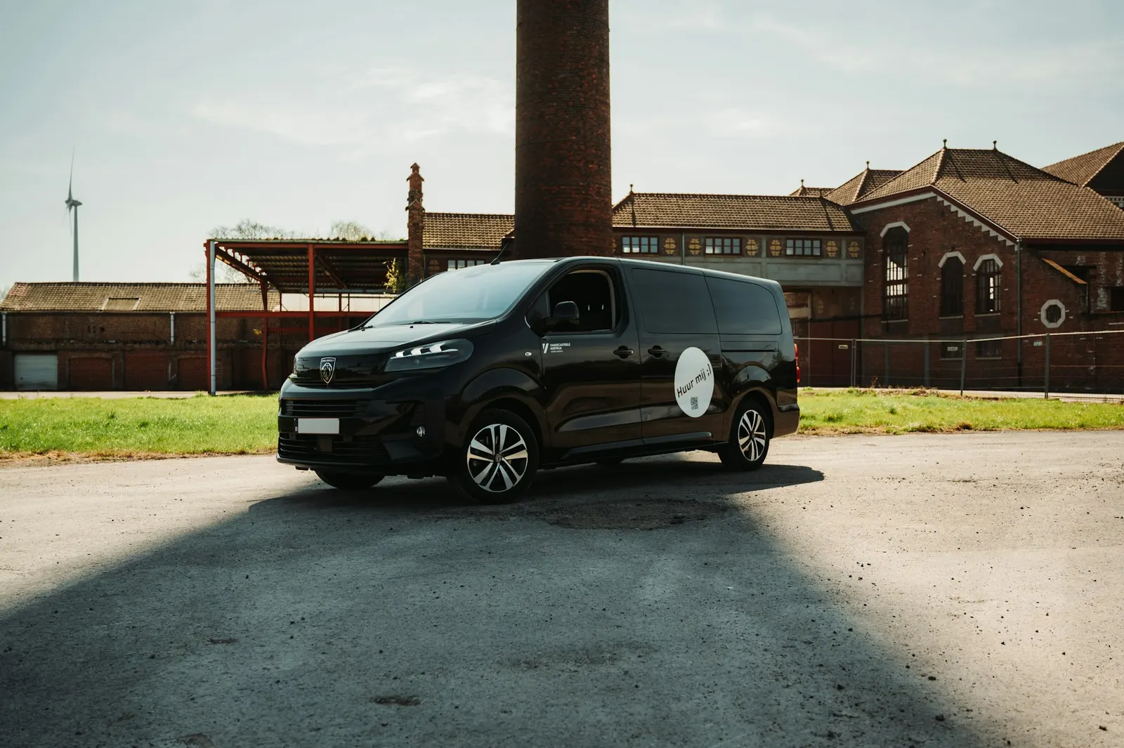 Black work van parked outside an industrial building, ready for mobile jobs