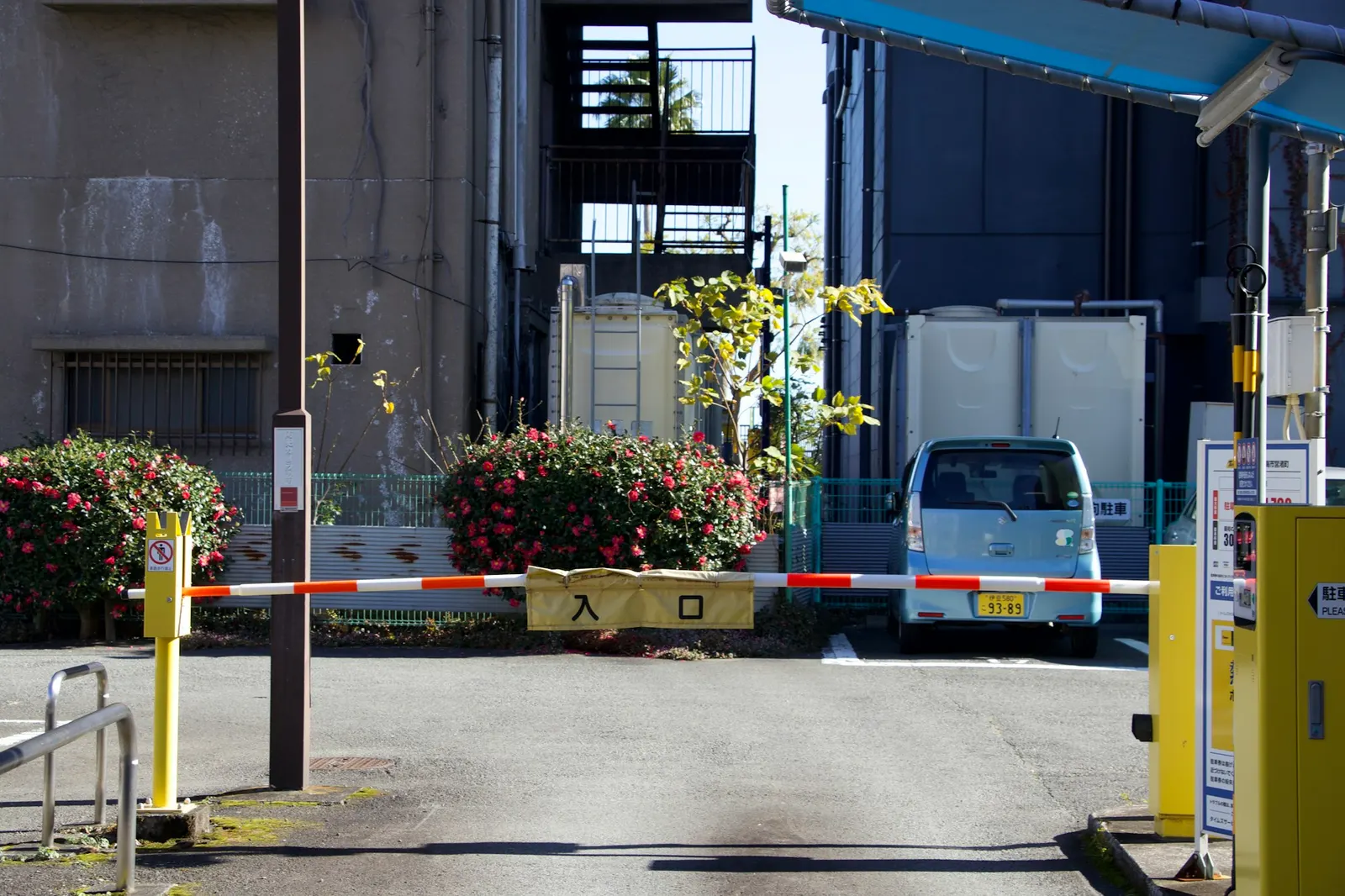 Automated barrier gate at a parking lot entrance with a van waiting behind it