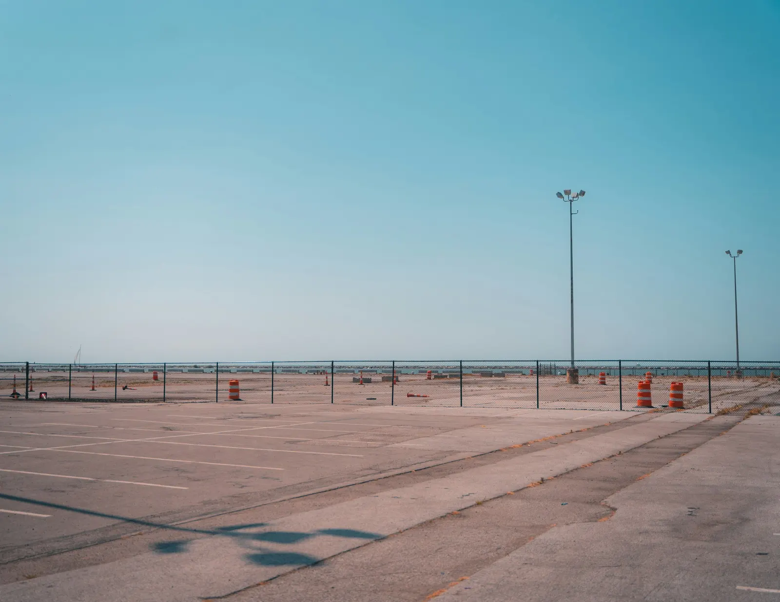 Empty paved parking lot with freshly painted line striping under a clear sky
