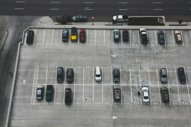 Aerial view of a busy paved parking lot filled with cars downtown