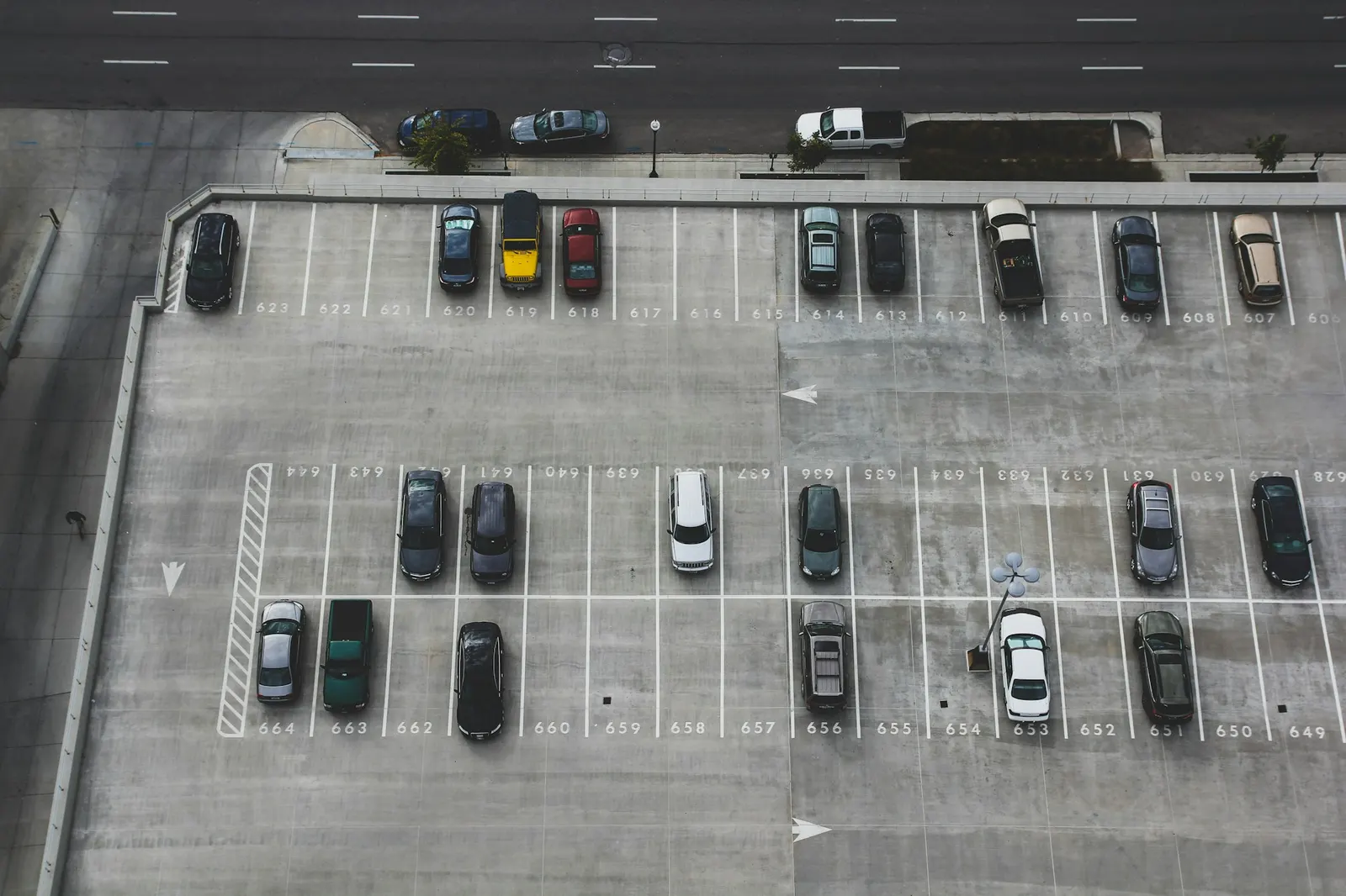 Aerial view of a busy paved parking lot filled with cars downtown
