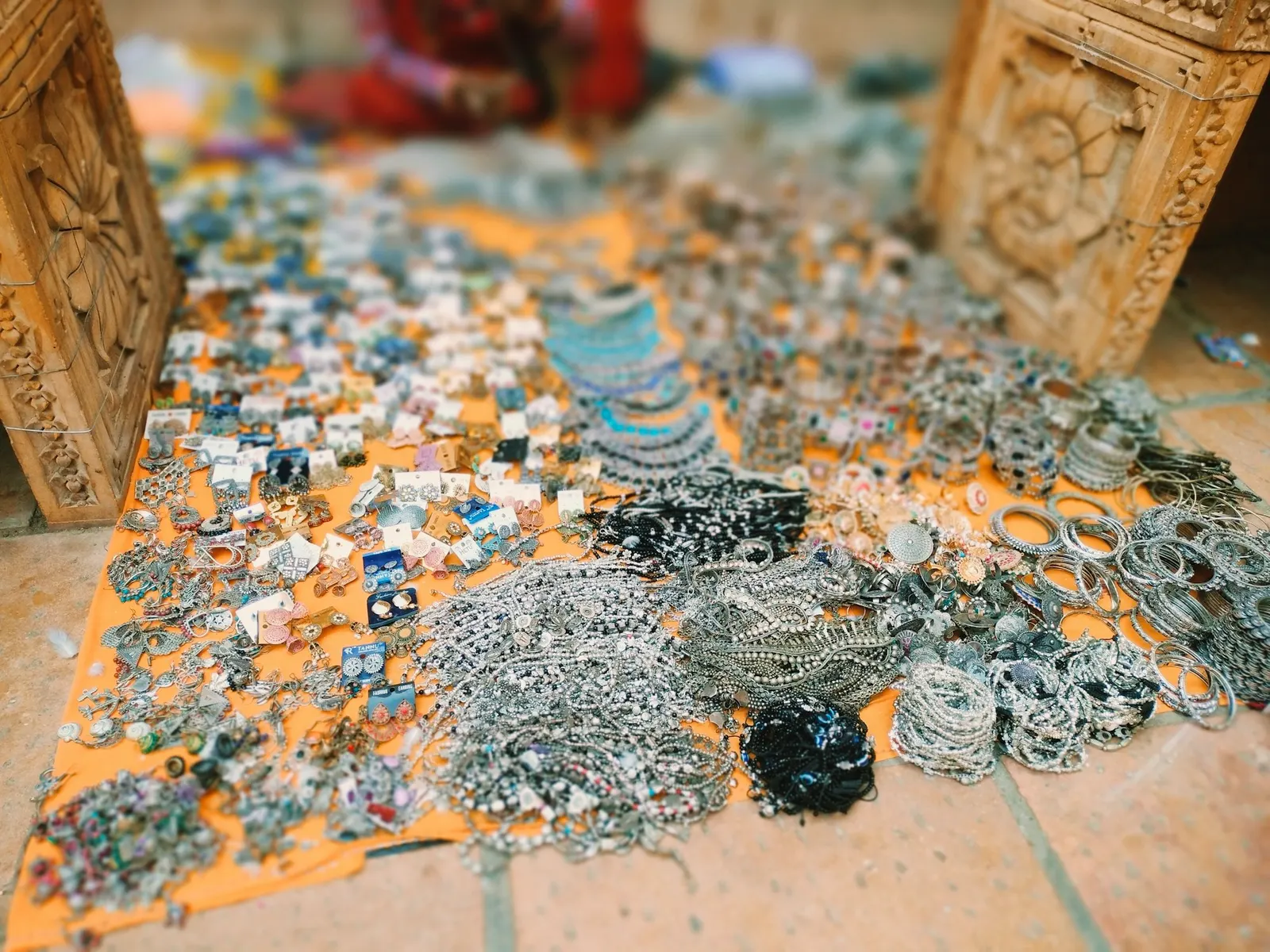 Handmade chains and bracelets displayed on a cloth at a pop-up jewelry table