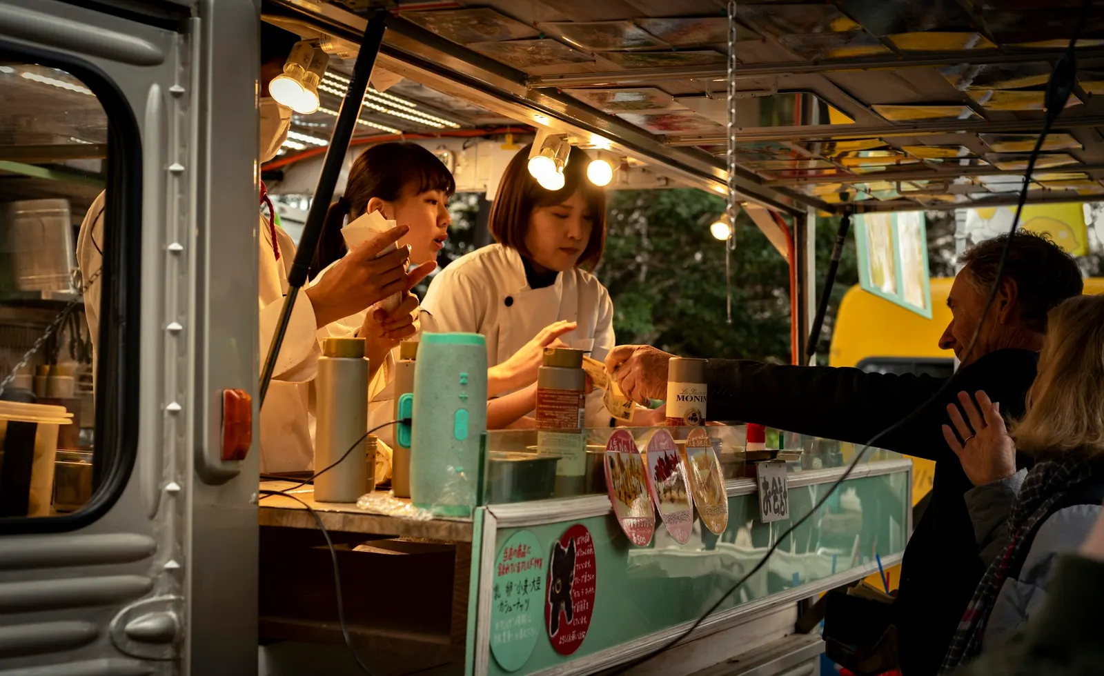 Crowd of customers gathered around a food truck at an outdoor summer event