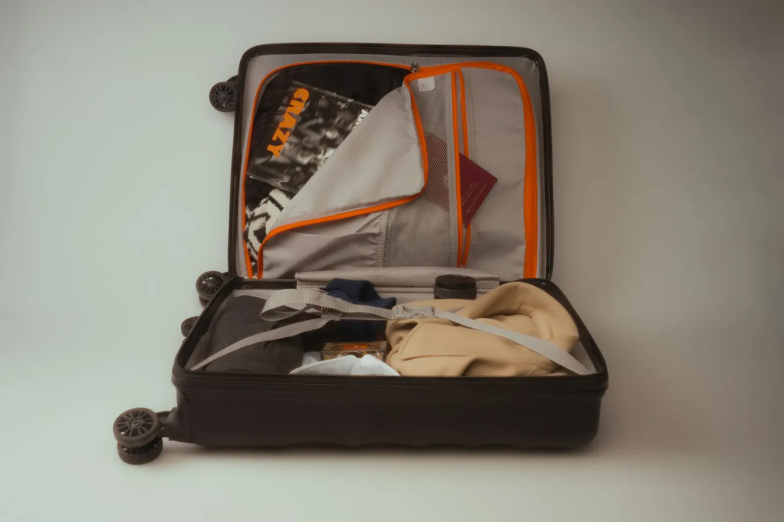 Open suitcase packed with clothes, passport and travel essentials