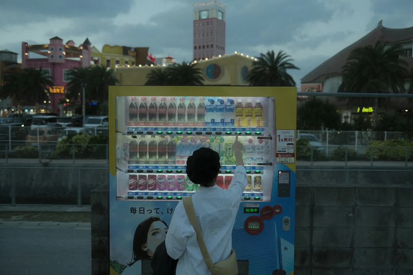 Customer selecting a drink from a brightly lit vending machine