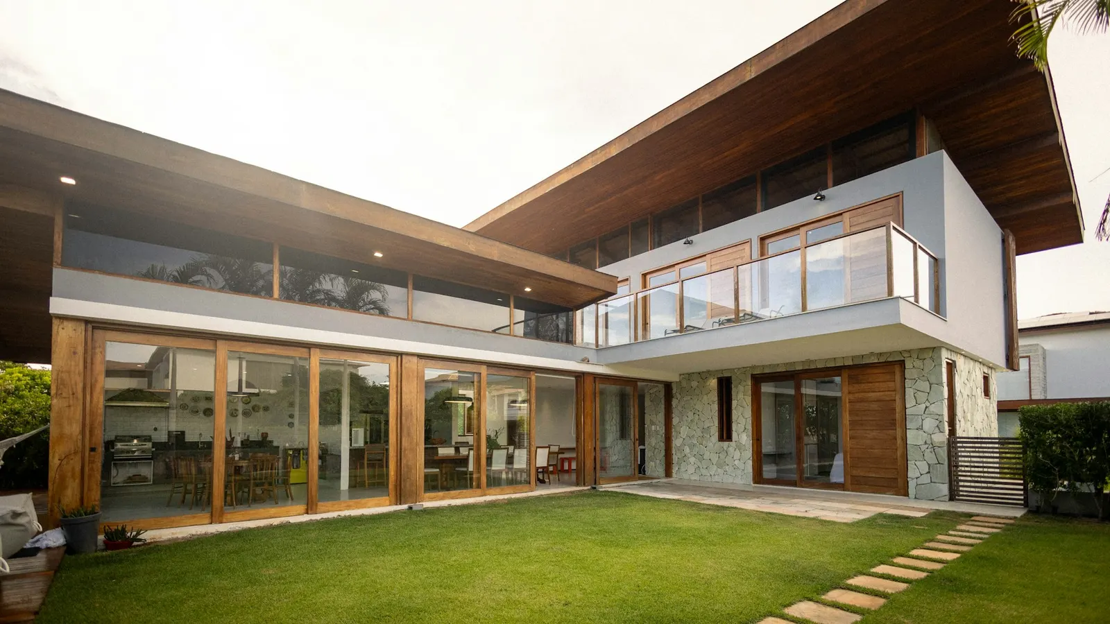 Modern house with floor-to-ceiling windows and a neatly kept green lawn