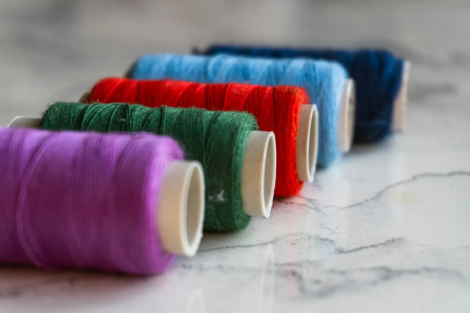 Spools of colorful embroidery thread arranged in a neat line