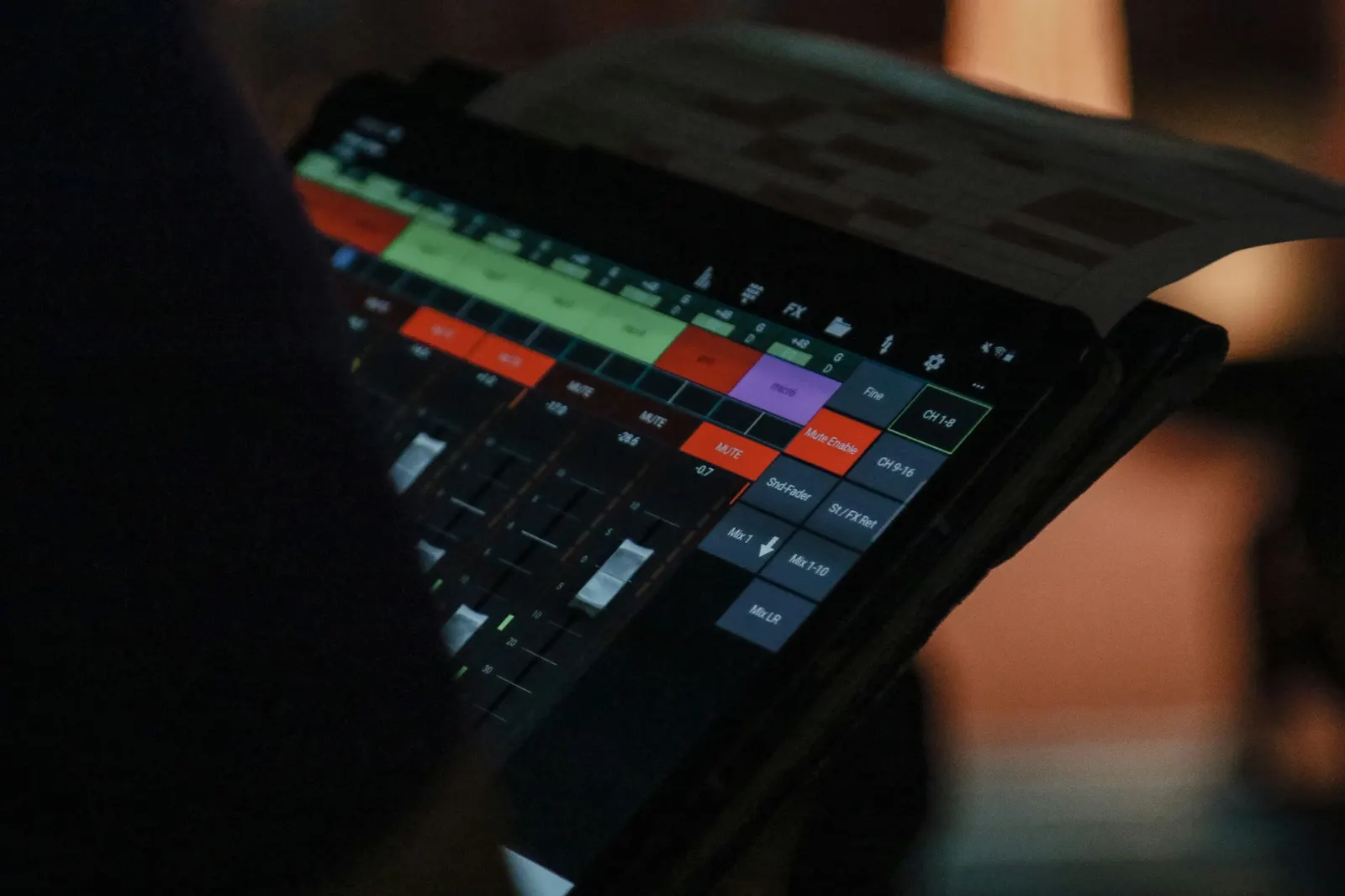 Event technician checking a show control tablet backstage in low light